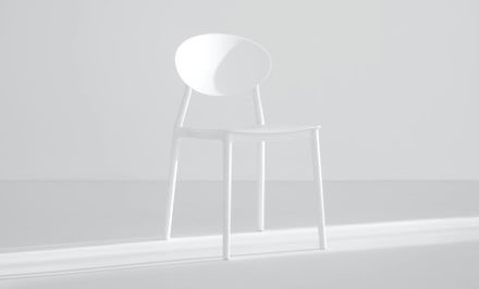 Brightly lit white room with white chair